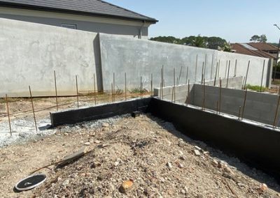 Waterproofing retaining wall foundation