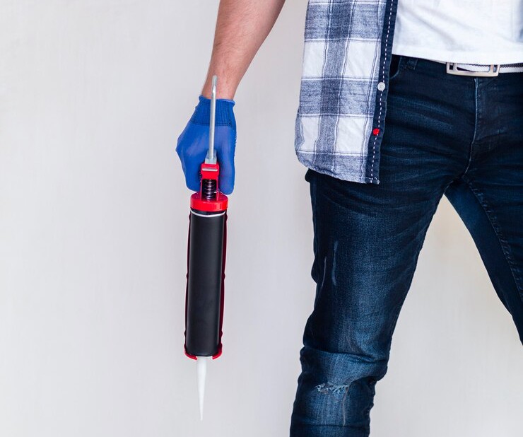 Worker holding a silicon gun for concrete crack injection repair