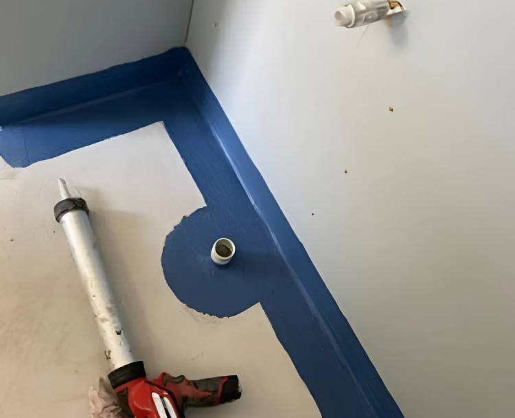 Close-up of a joint sealing tool on a bathroom floor