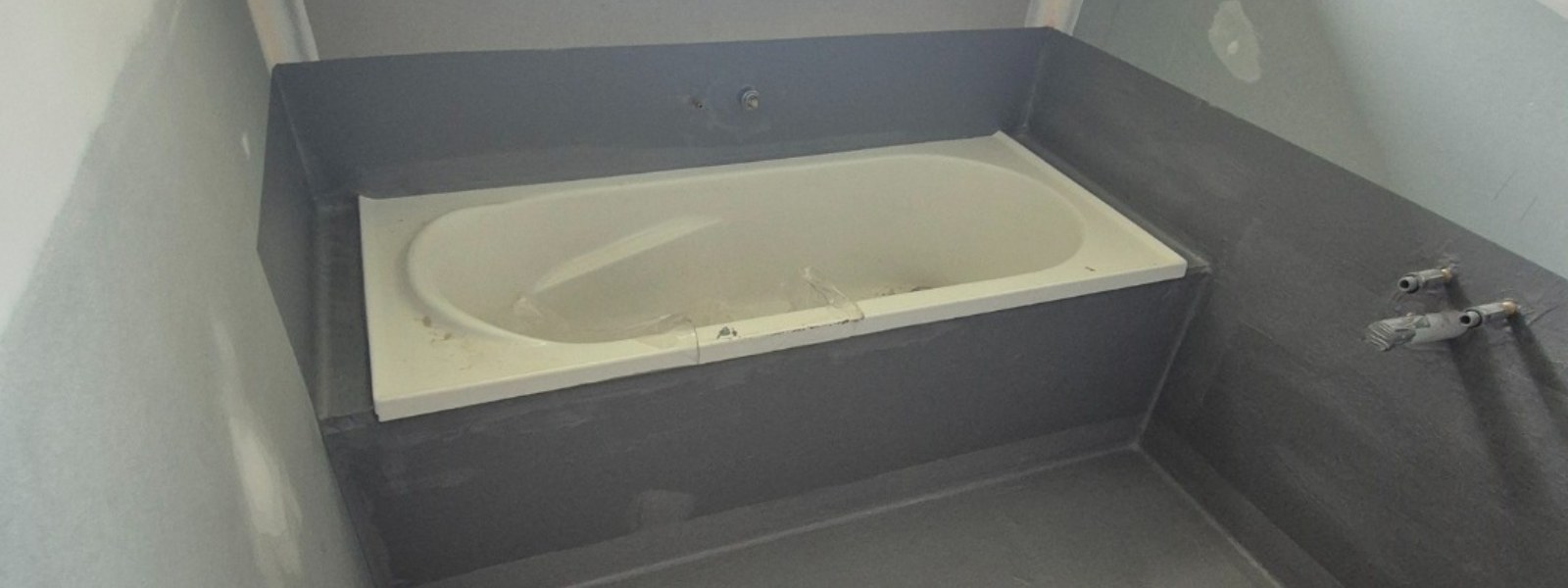 Bathroom waterproofing over concrete with a bathtub installed